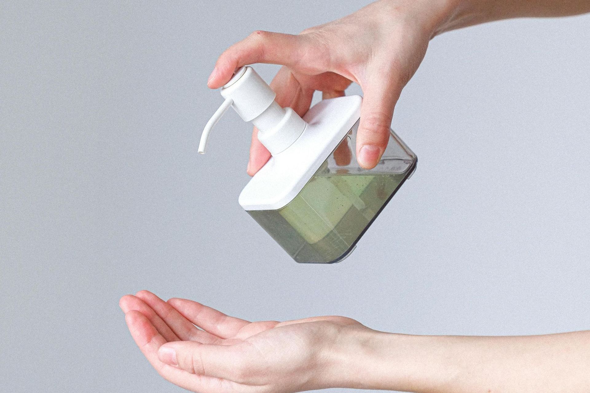 Eine Person trägt ein Handdesinfektionsmittel auf ihre Hände auf.
