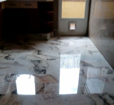 Un suelo de mármol en una cocina con puerta para gatos.