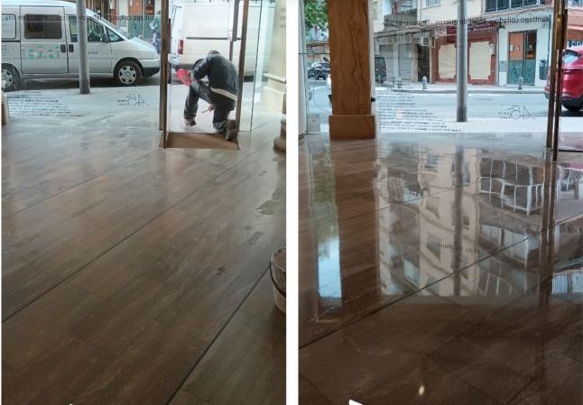 Un hombre está limpiando un piso de mármol con una escoba.