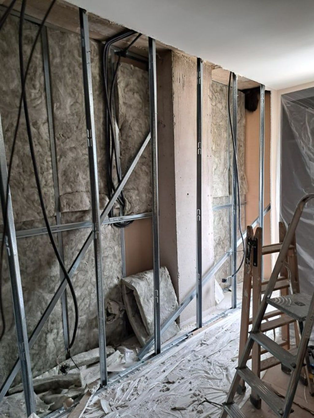 Una habitación en construcción con una escalera y una escalera.