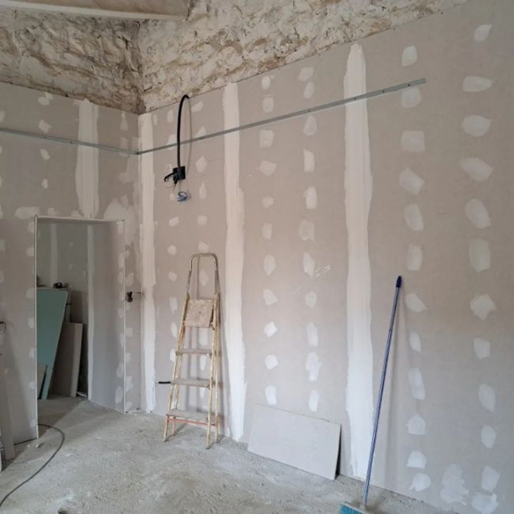 Una habitación con una escalera y un trapeador dentro.