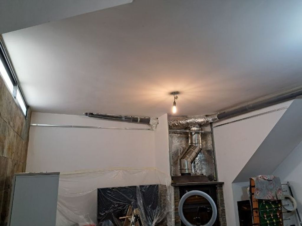 Una habitación con un techo que tiene una luz y una chimenea.