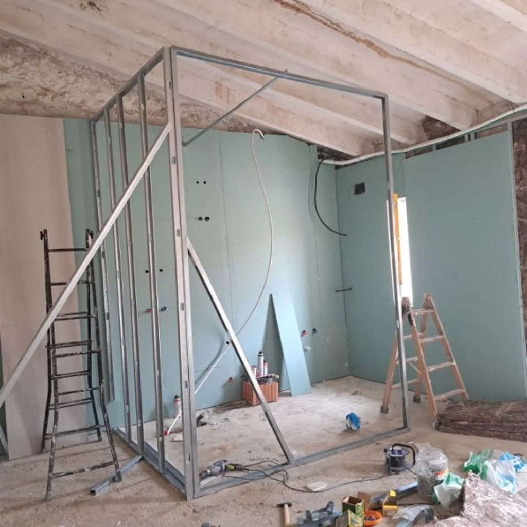 Una habitación en construcción con una estructura de metal y una escalera.