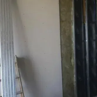 Una escalera está apoyada junto a una pared en una habitación.