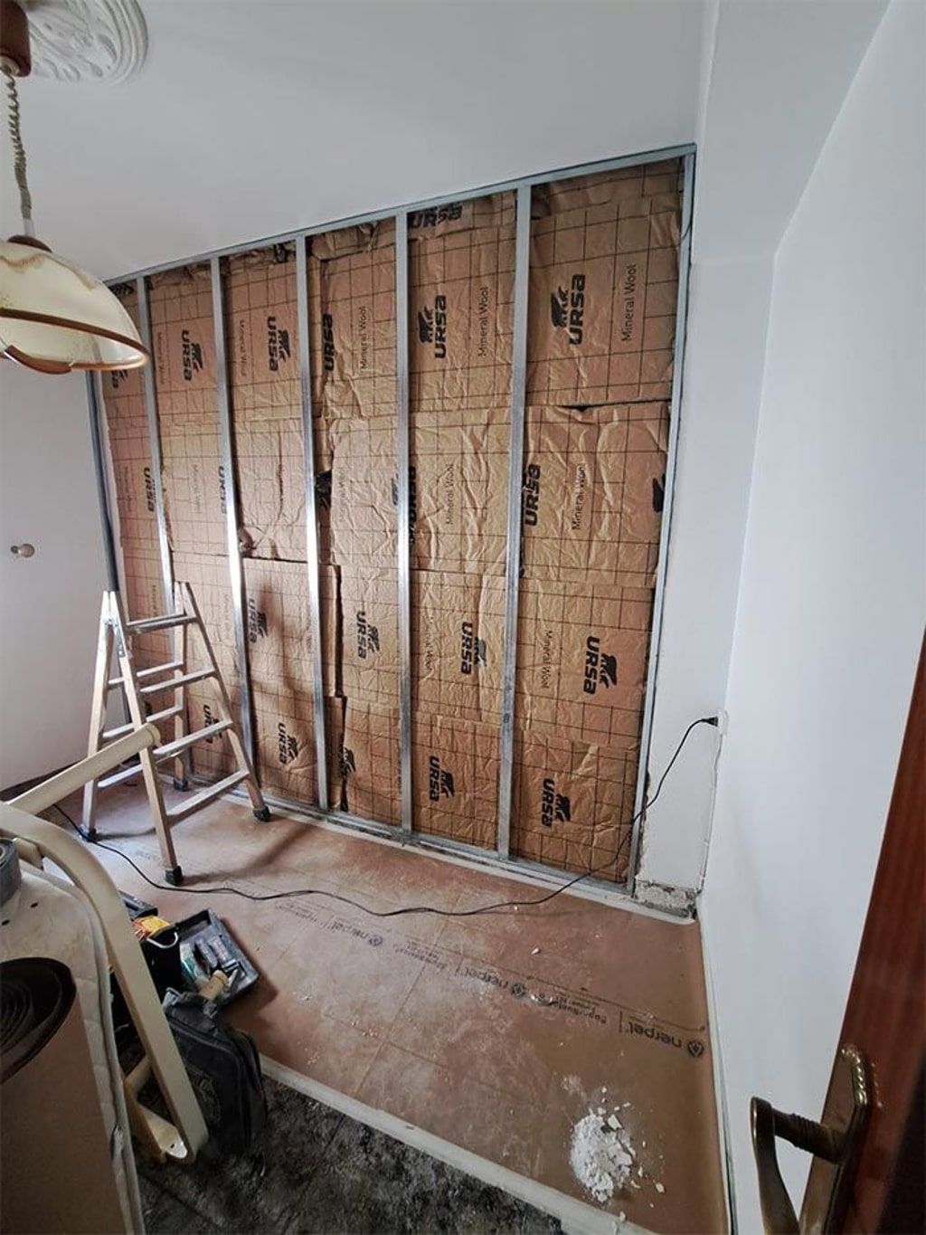 Una habitación con una escalera y una pared con aislamiento.