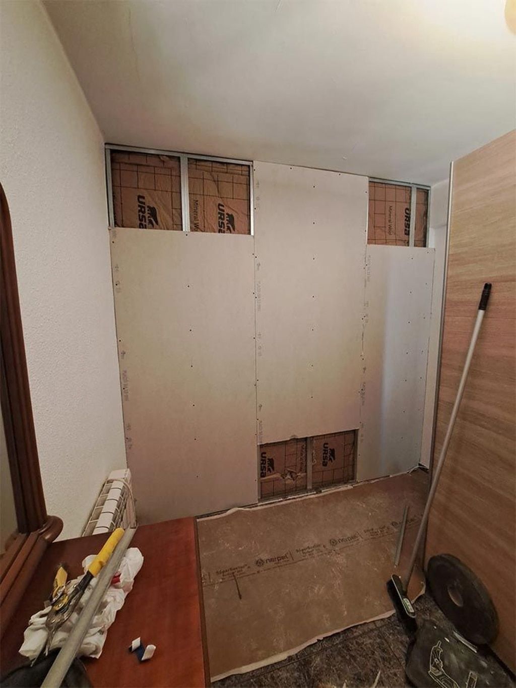 Una habitación con muchas paredes y una escoba en el suelo.