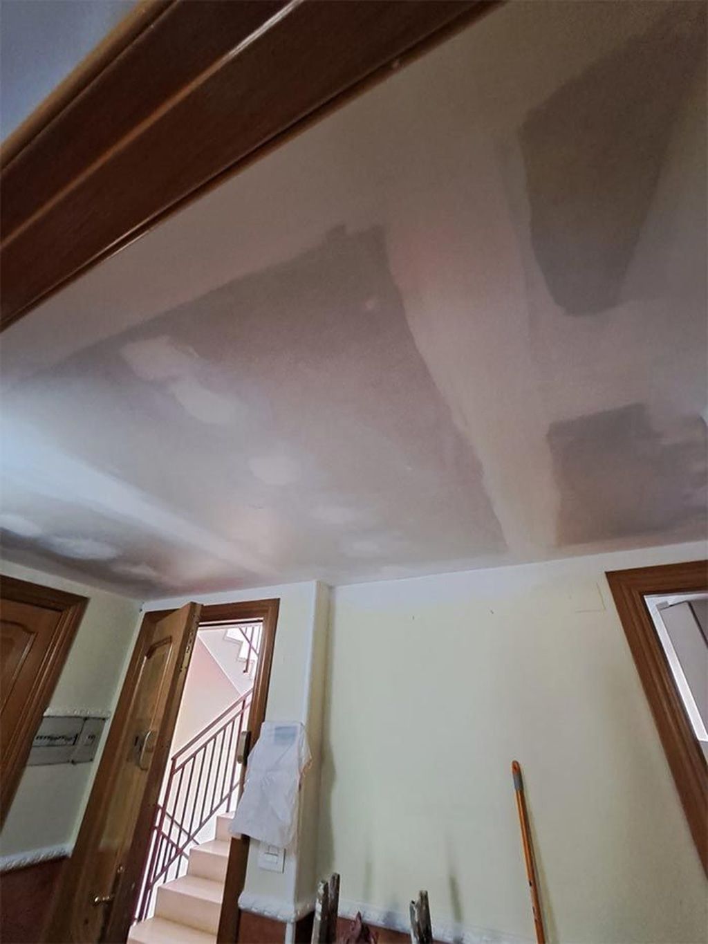 Una habitación con techo blanco y una puerta de madera.