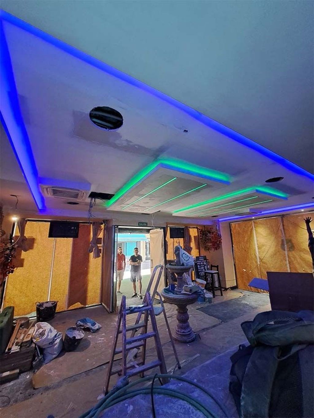 Una habitación con un techo azul y verde y una escalera.