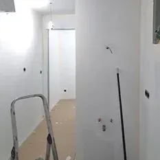 Una escalera está en un pasillo al lado de una puerta.