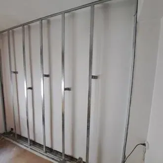 Una habitación con una hilera de marcos de metal en la pared.