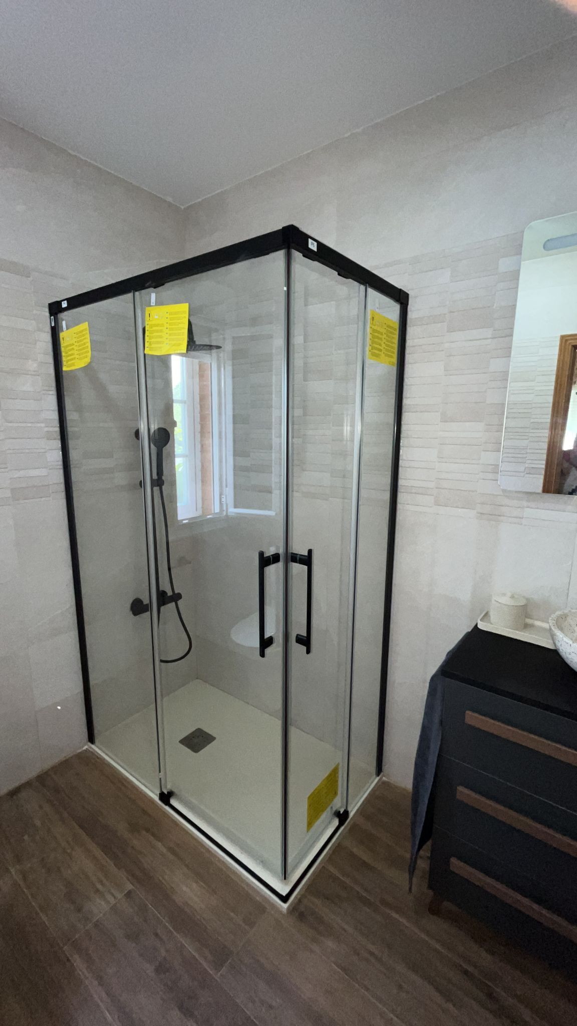 Un baño con cabina de ducha y espejo.