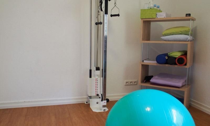 Ein blauer Gymnastikball liegt in einem Raum neben einem Regal.