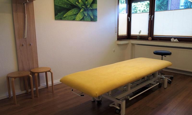Ein Zimmer mit einem gelben Bett und zwei Hockern
