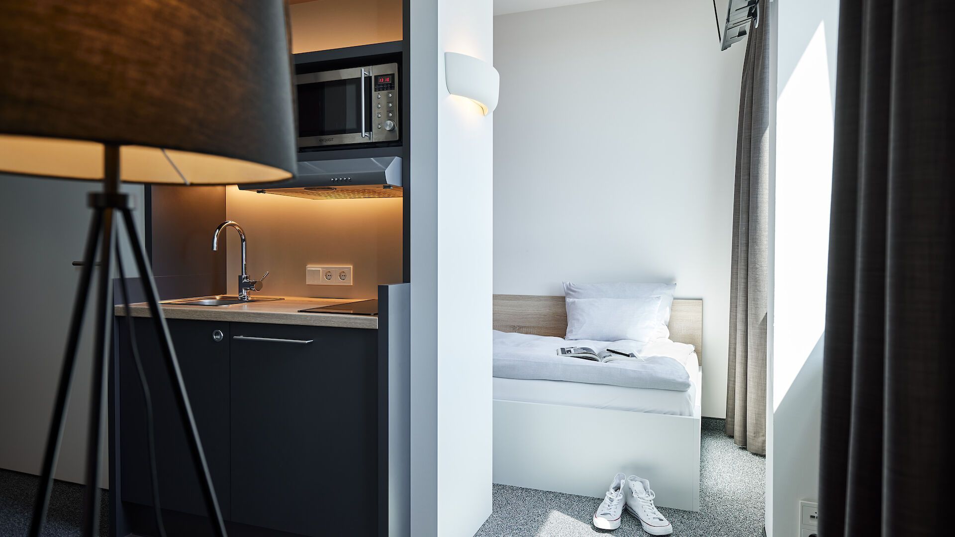 Ein Hotelzimmer mit einem Einzelbett und einer Lampe