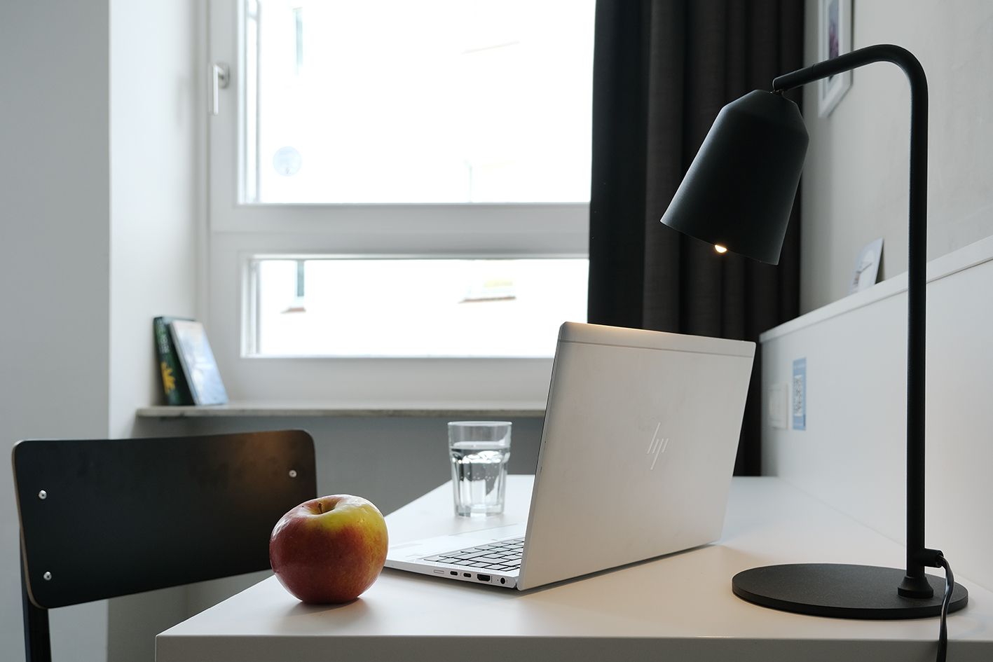 Ein Schreibtisch mit einem Laptop und einem Apfel darauf