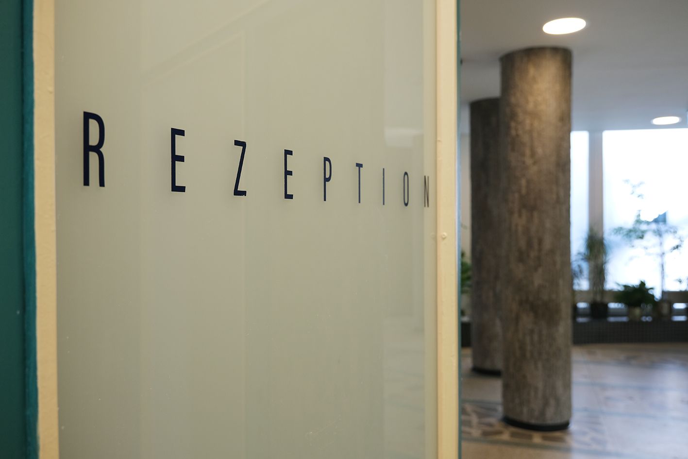 Eine Glastür mit der Aufschrift „Rezeption“