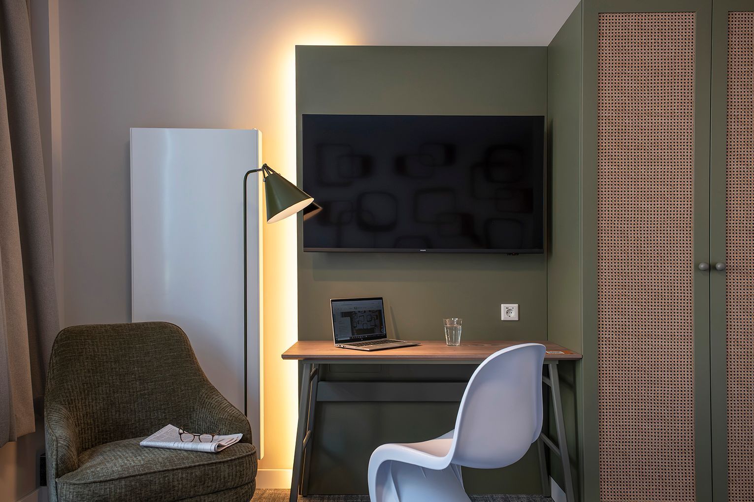 Eine Küche mit Mikrowelle, Spüle und in einem Schrank hängender Kleidung.