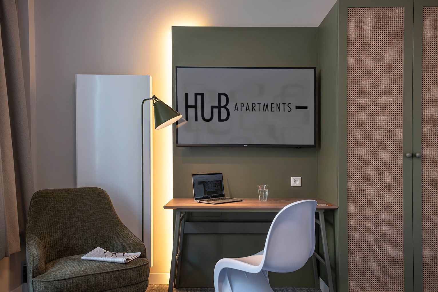 Ein Schlafzimmer mit Bett, Stuhl, Lampe und Fenster.