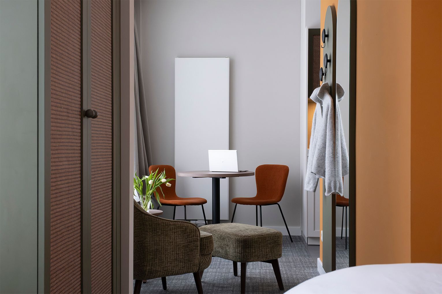 Ein Schlafzimmer mit Bett, Stuhl, Lampe und Fenster.