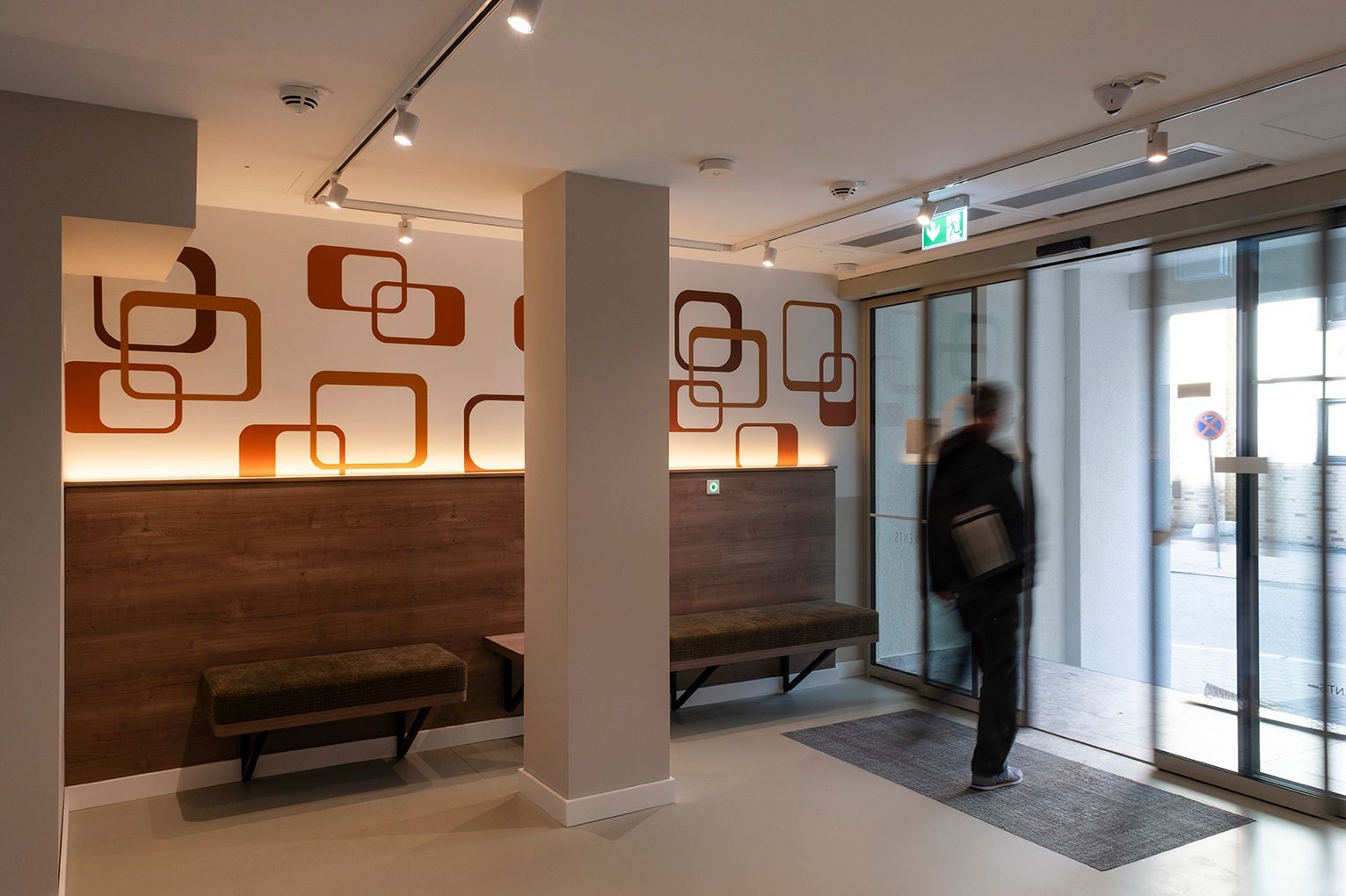 Eingangsbereich HUB Apartments St Georg mit Sitzgelegenheiten und Glastür