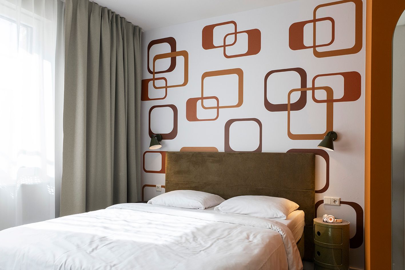 Ein Schlafzimmer mit einem Bett und einer Wand mit Quadraten darauf