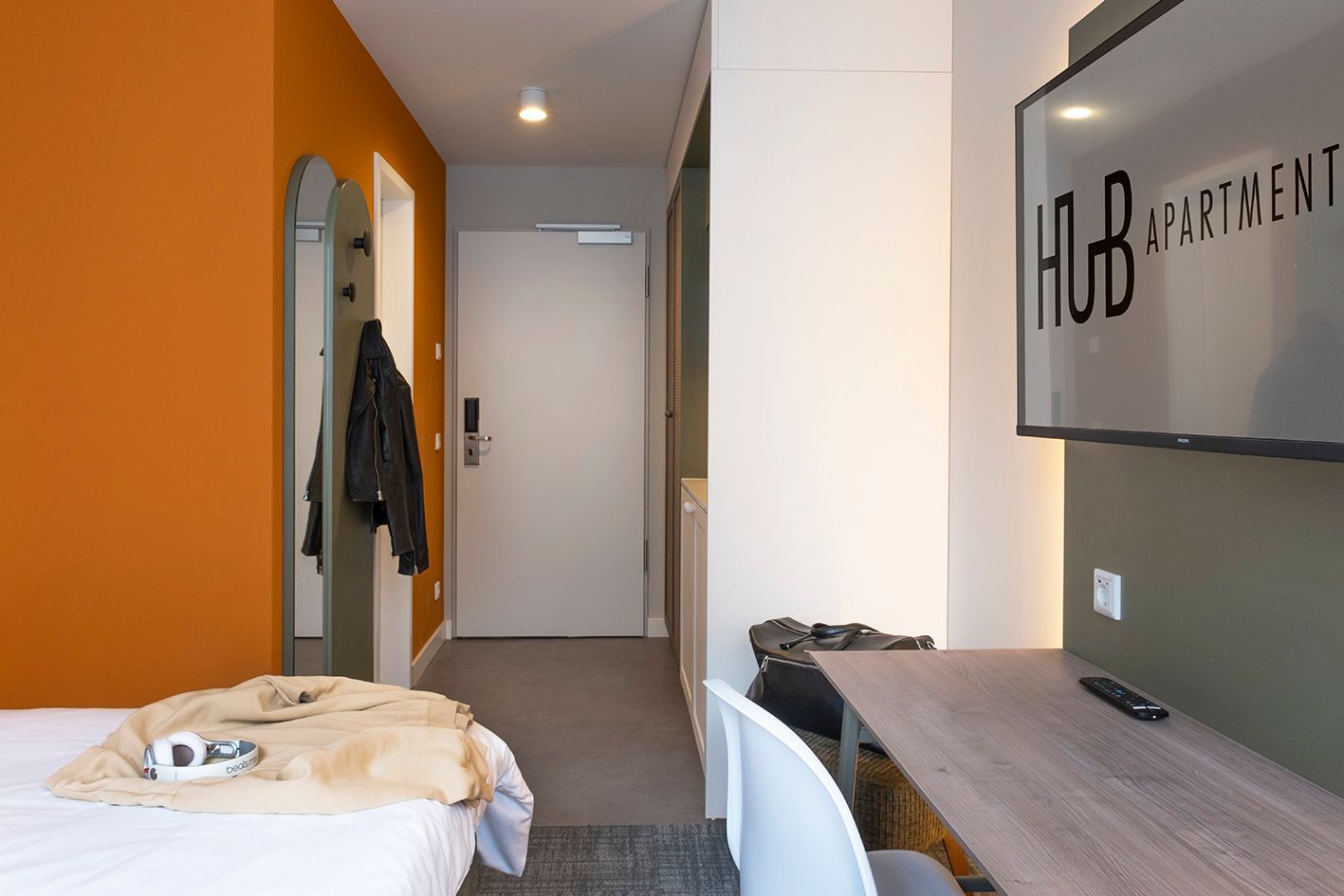 Ein Hotelzimmer mit Bett, Schreibtisch und Fernseher.