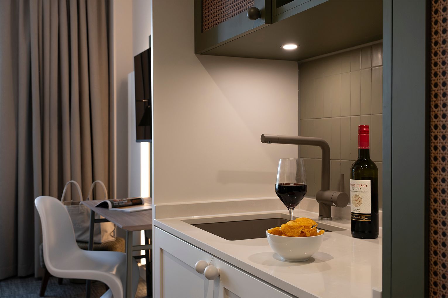 Ein Schlafzimmer mit einem Bett und eine Küche mit Mikrowelle und Spüle.