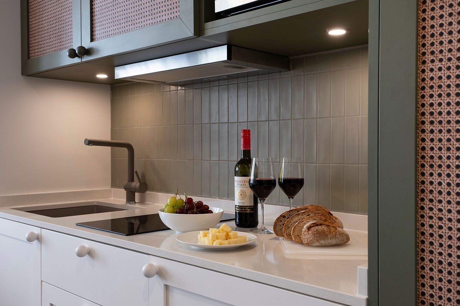 Kitchenette eines Apartments mit frischen Lebensmitteln & Wein
