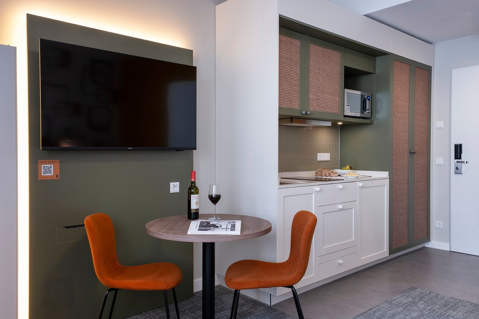 Ein Hotelzimmer mit Bett, Schreibtisch, Waschbecken und Mikrowelle