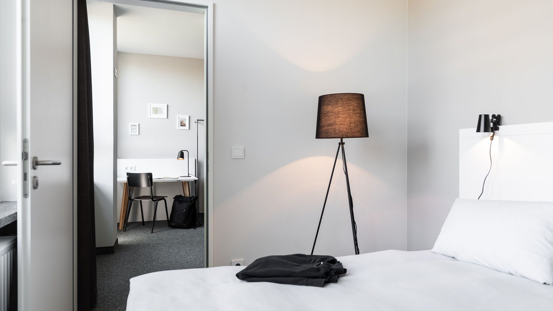 Ein Schlafzimmer mit Bett, Lampe und Schreibtisch