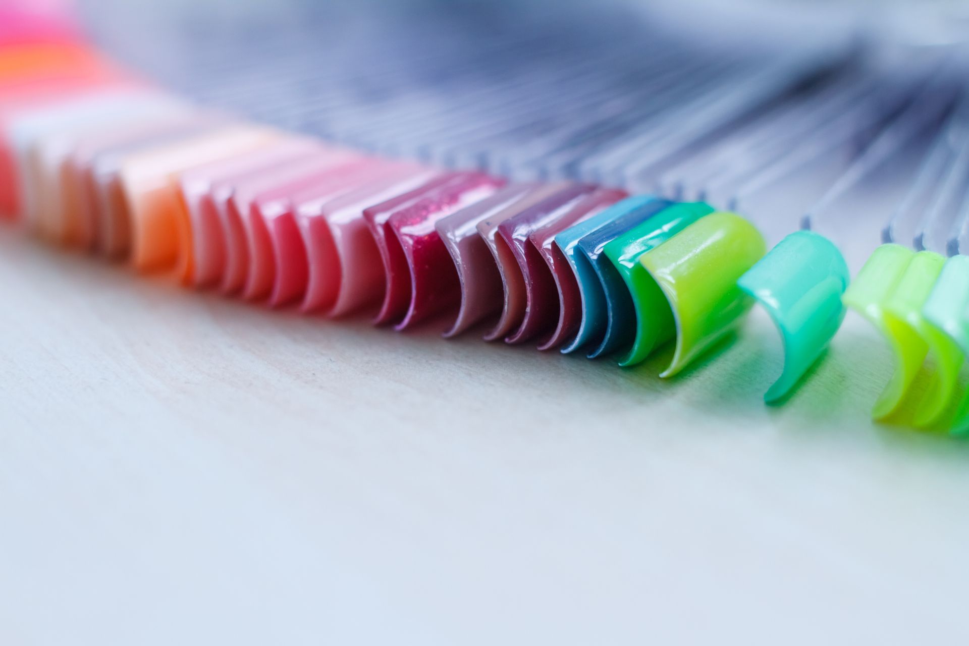 Des échantillons de vernis à ongles étalés en éventail présentaient différentes nuances, allant du nude au néon éclatant.