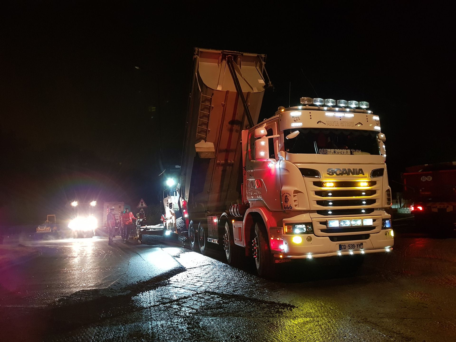 Camion-benne Scania de nuit sur un chantier routier