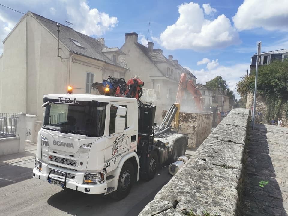 Poids lourd blanc devant une benne et une pelleteuse