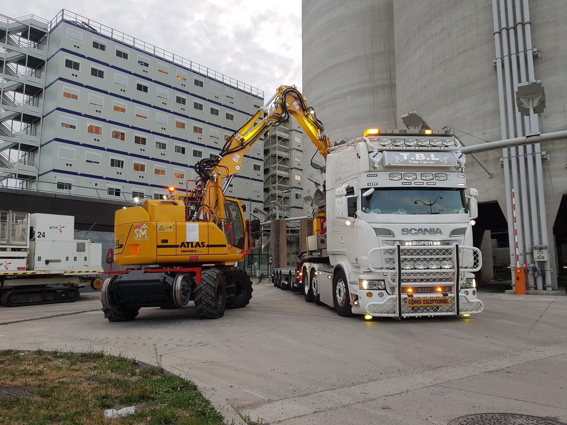 Pelleteuse jaune de la marque Atlas devant un porte-engin