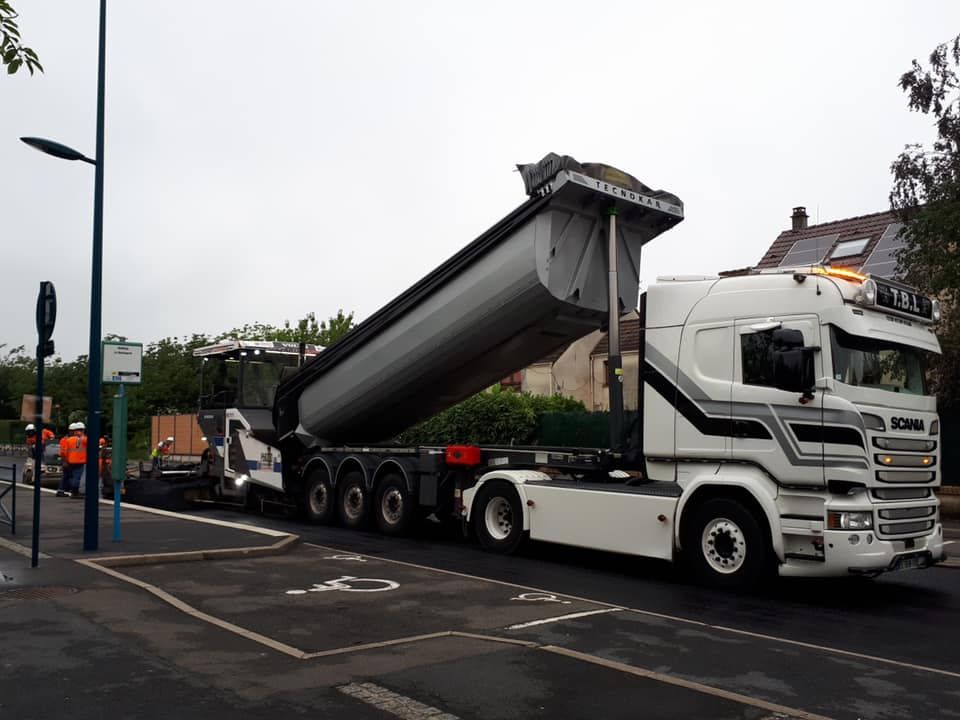 Camion avec benne relevée, près d'une place pour personne handicapée