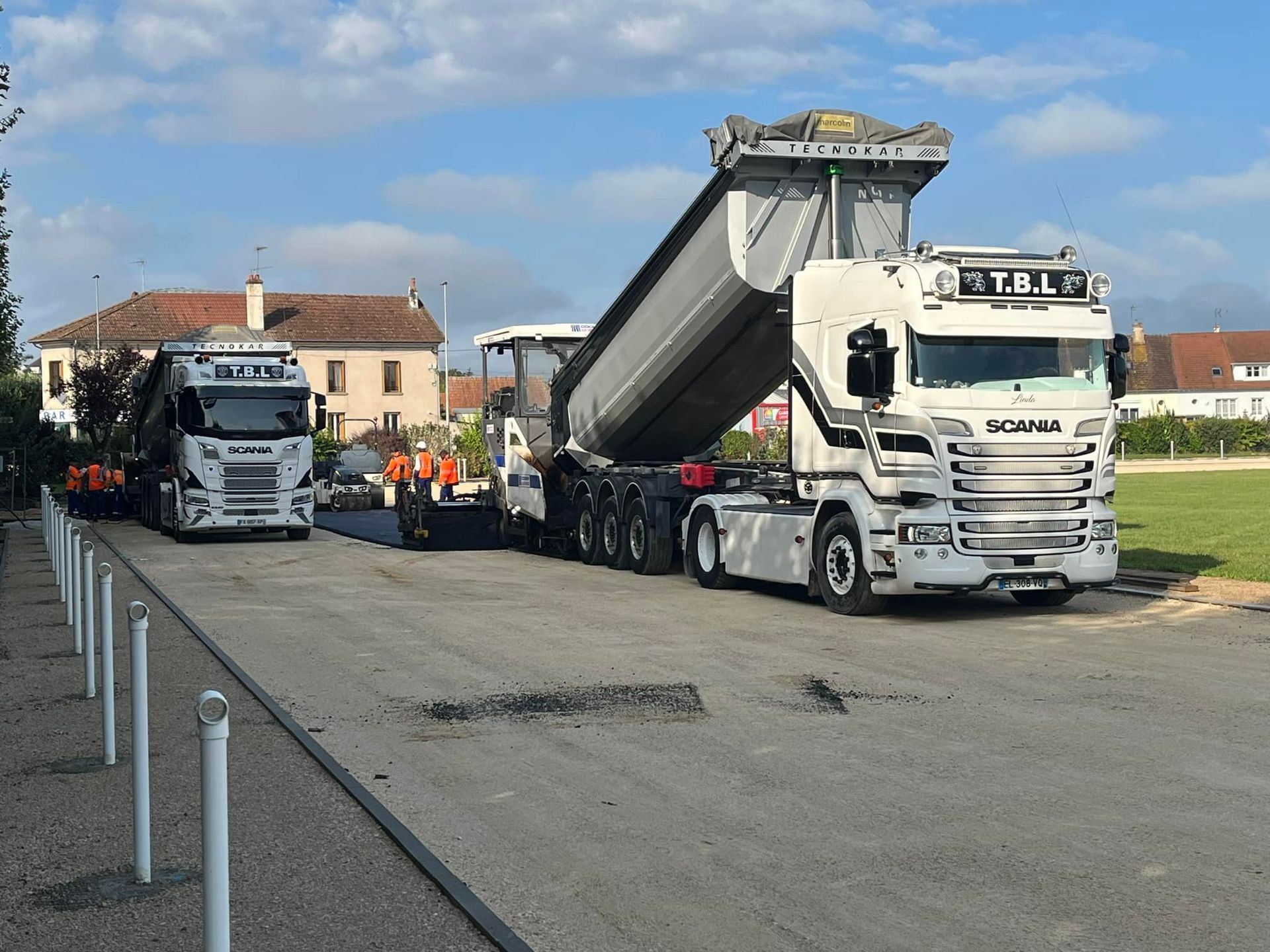 Un poids lourd en train de déverser l'enrobage pour la route