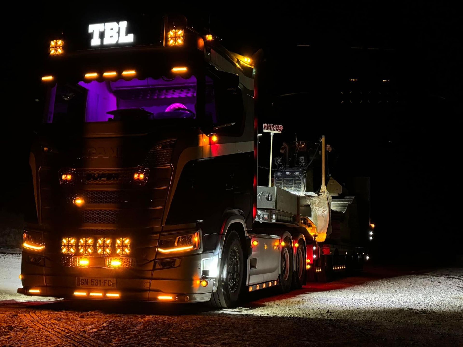 Un poids lourd de nuit transportant un engin