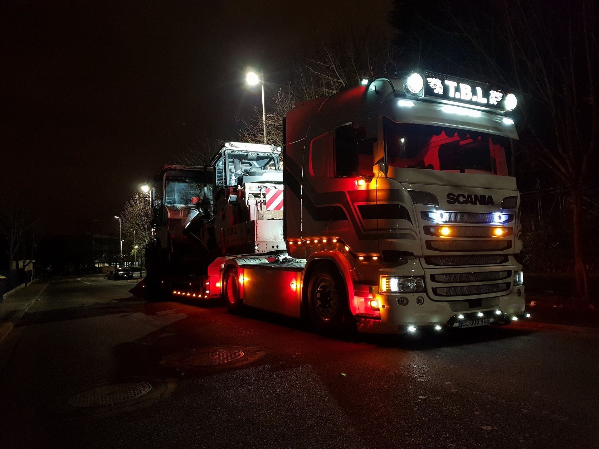 Véhicule Scania transportant un engin de nuit