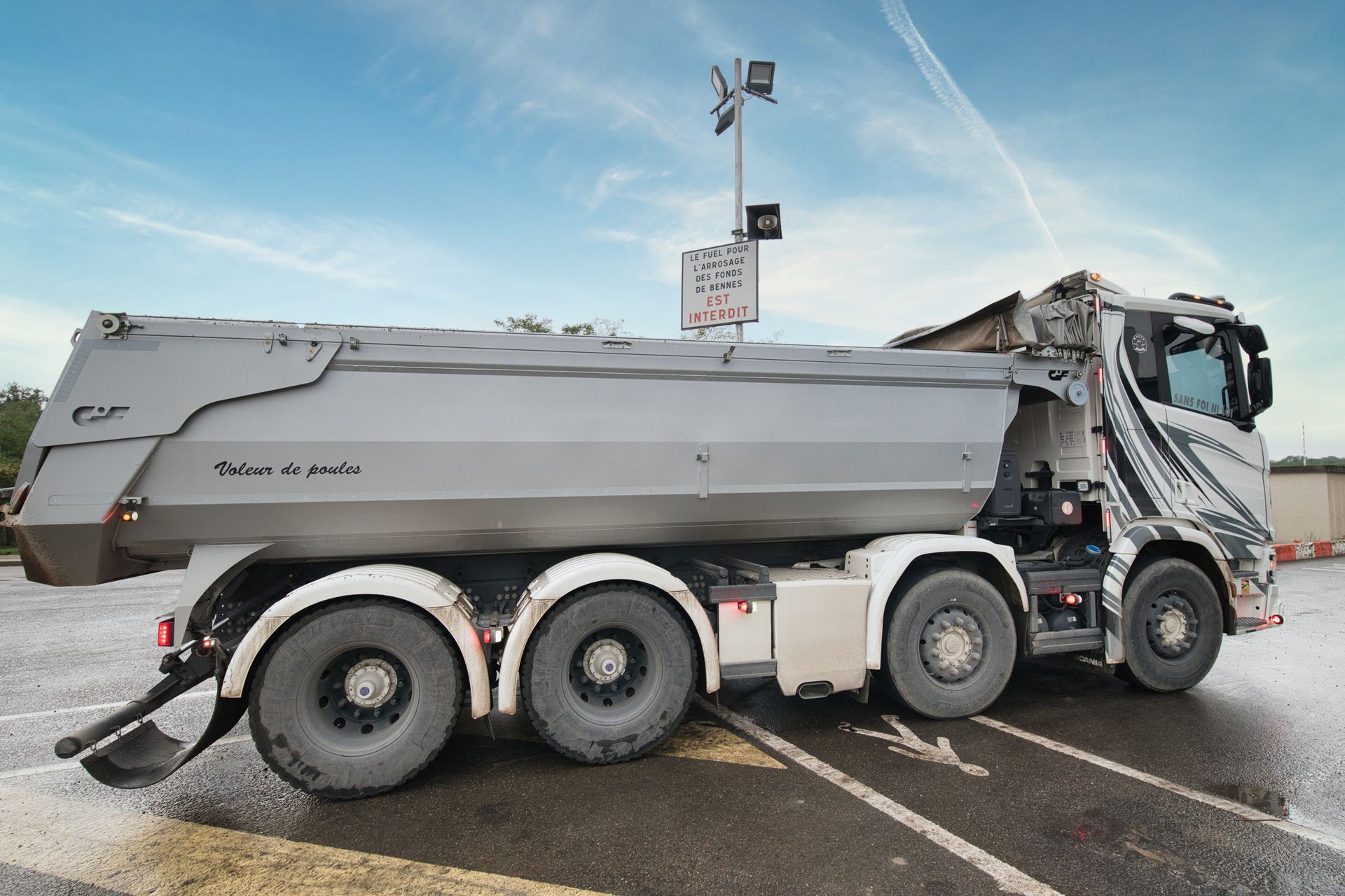 Camion benne de côté sur un parking
