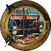 Escena de un restaurante vista a través de un marco circular de madera con un letrero rojo que dice 