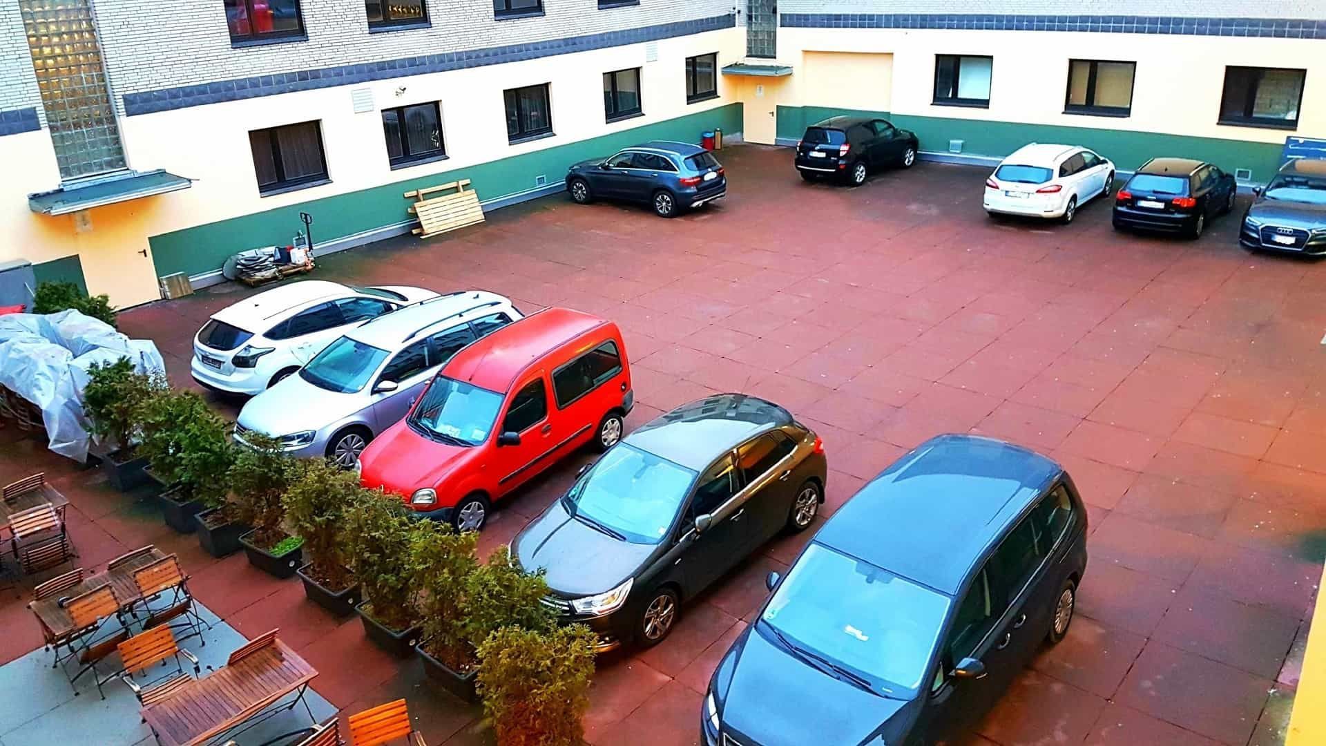 Im Innenhof sind Autos geparkt. Man sieht Fahrzeuge in verschiedenen Farben.