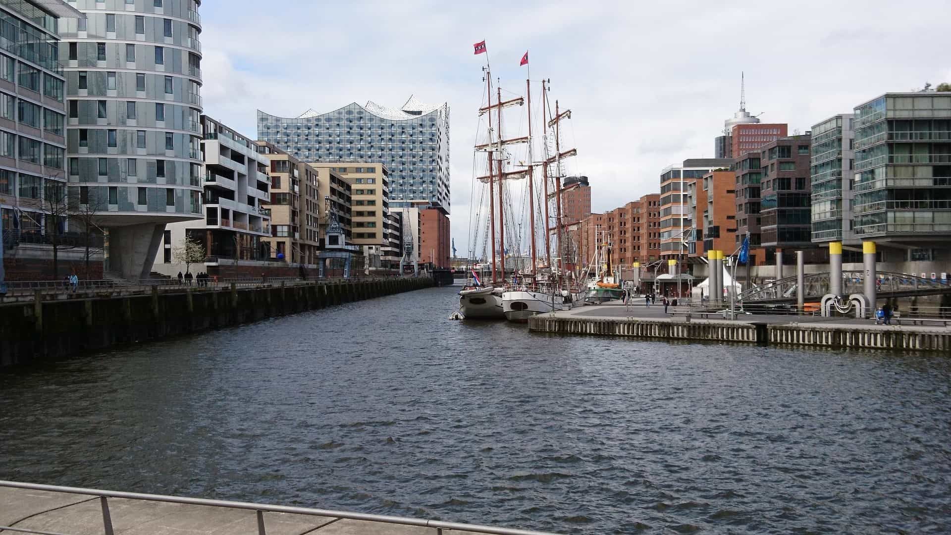 Wasserkanal mit ankernden Segelbooten und modernen Gebäuden in Hamburg, Deutschland.