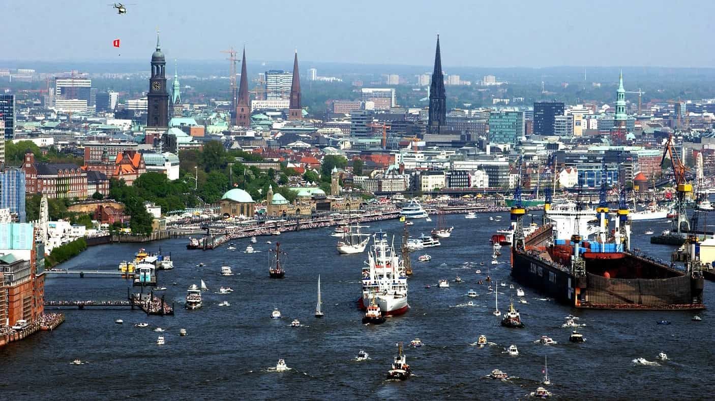 Der Hamburger Hafen mit zahlreichen Booten, hohen Gebäuden und klarem Himmel.