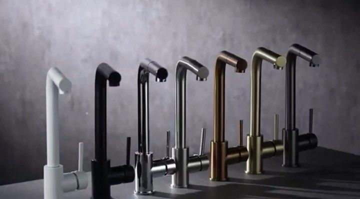 Elegante y moderna gama de grifos de cocina en acabados blanco, negro, plateado, bronce y latón sobre encimera.