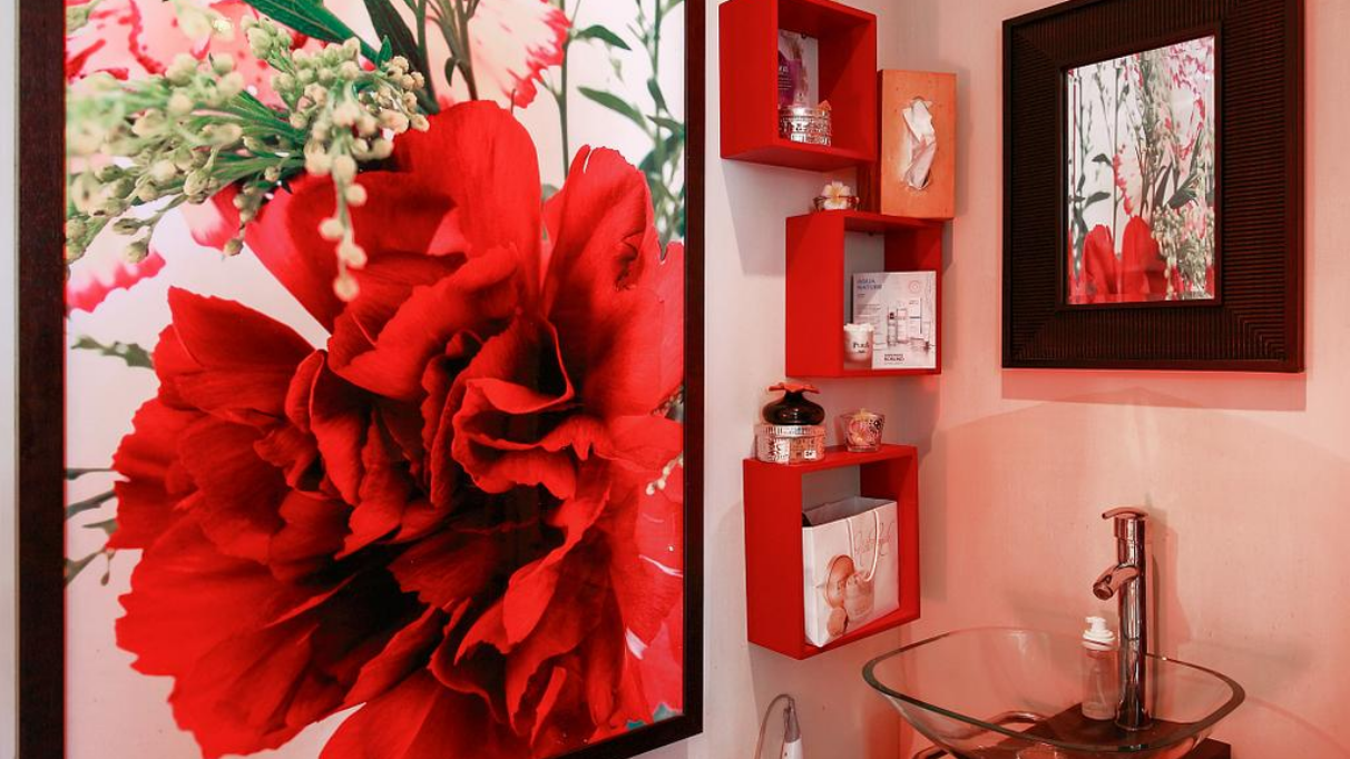 Gros plan décoratif de fleur rouge avec étagères murales contenant des produits de beauté.