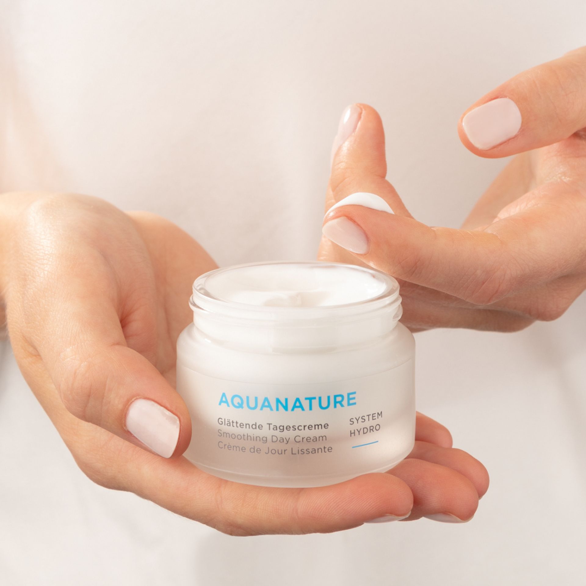 Une personne soulève délicatement la peau au-dessus de ses sourcils avec deux doigts, révélant des sourcils texturés et naturels ainsi qu'une peau éclatante.