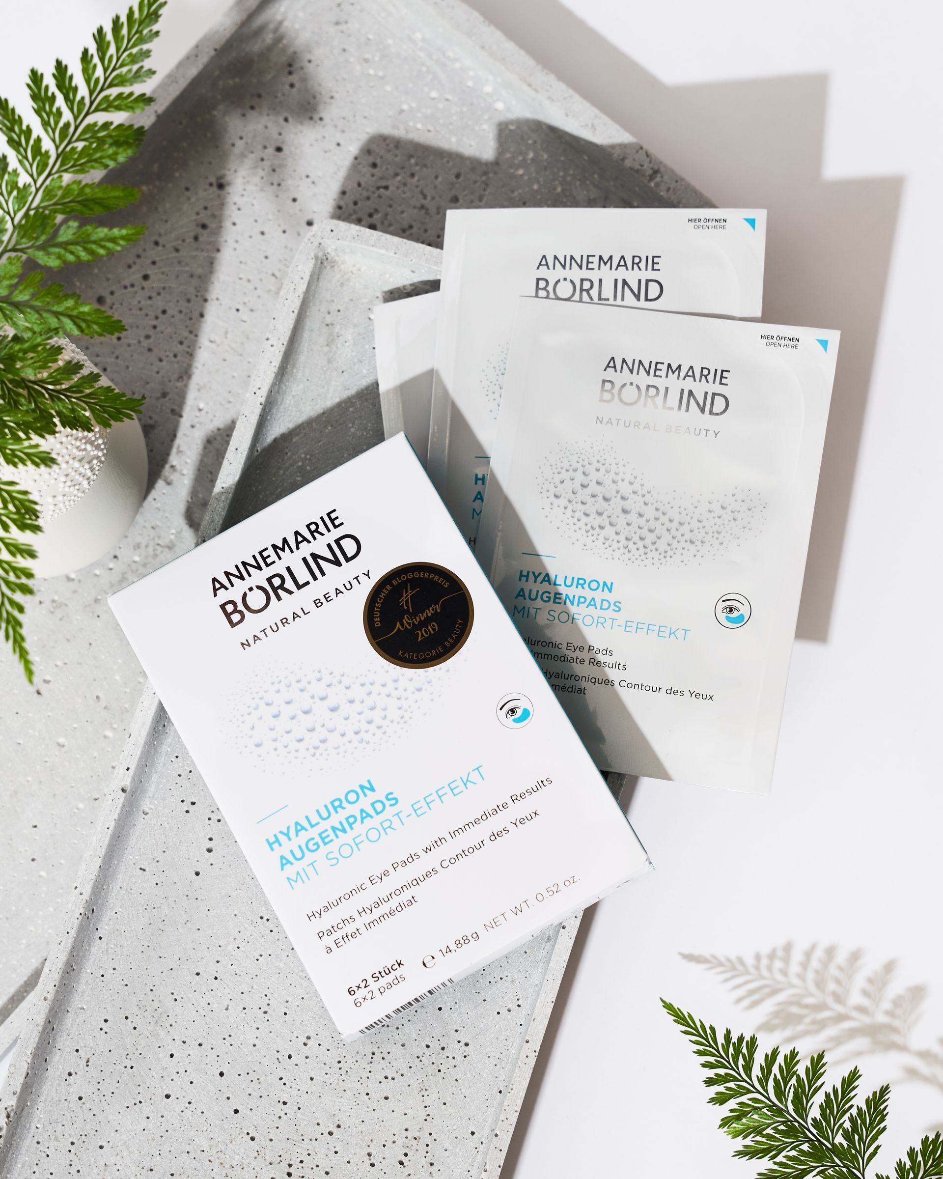 Une personne soulève délicatement la peau au-dessus de ses sourcils avec deux doigts, révélant des sourcils texturés et naturels ainsi qu'une peau éclatante.