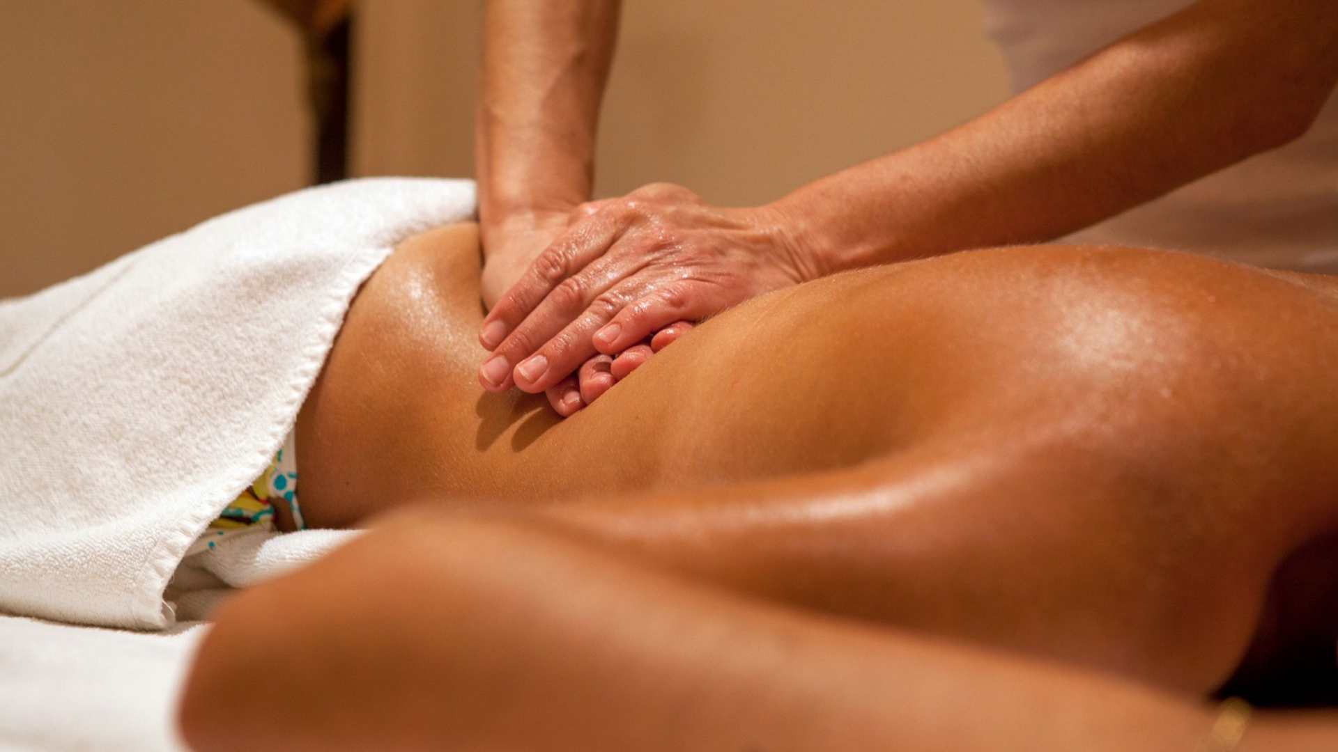 Femme allongée sur le ventre se faisant masser le dos