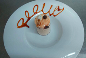 Postre en un plato blanco con un chorrito de caramelo que forma la palabra 