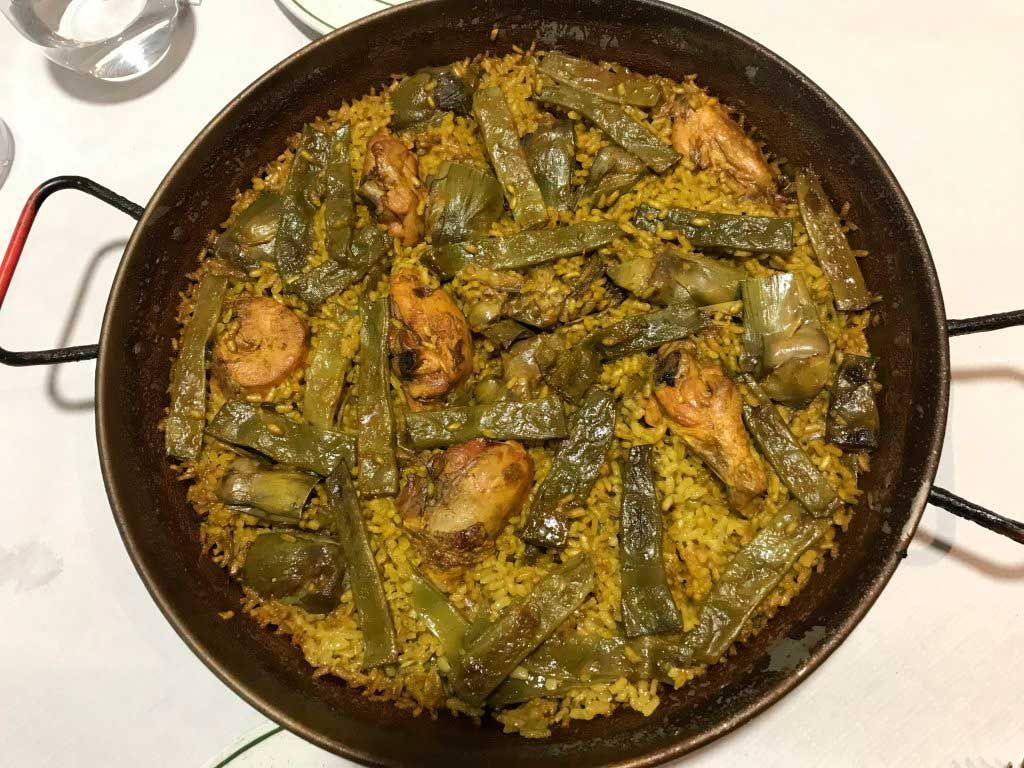 Guiso de verduras verdes con camarones cocinado en la estufa, servido en una sartén negra.